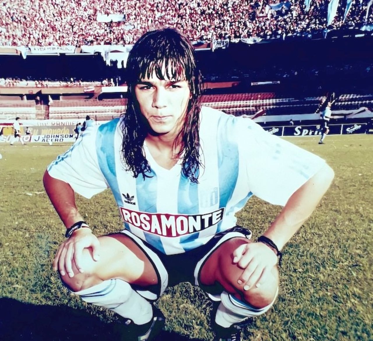 Aquí con la casaca de Racing y en el fondo la hinchada de La Academia.