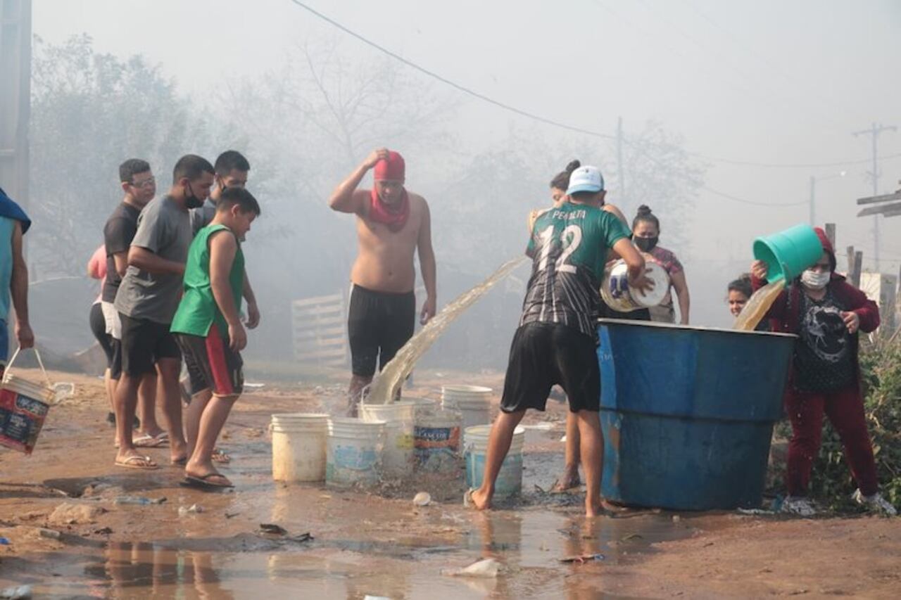 Los vecinos con baldes de agua ayudaban a apagar el fuego.