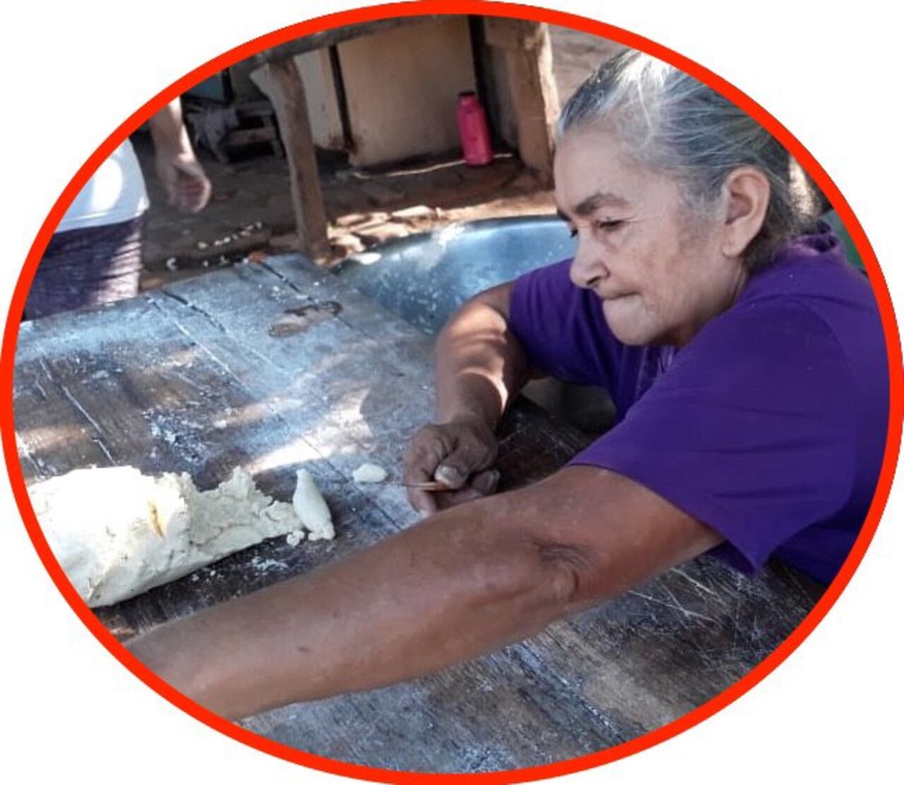 La doña amasando para la chipa.