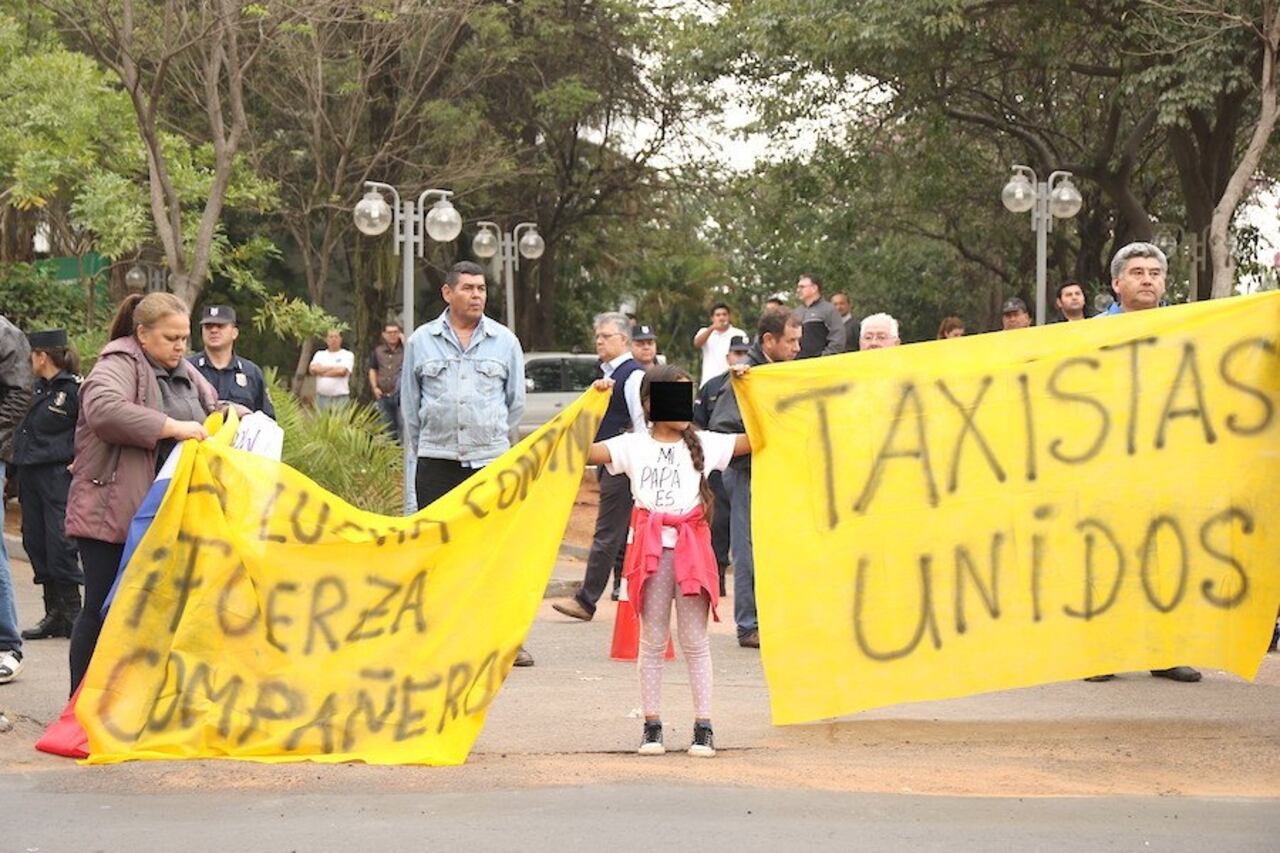 Muchos taxistas estuvieron acompañados por sus familiares. Aquí una niña sostiene una de las pancartas en apoyo a los conductores.