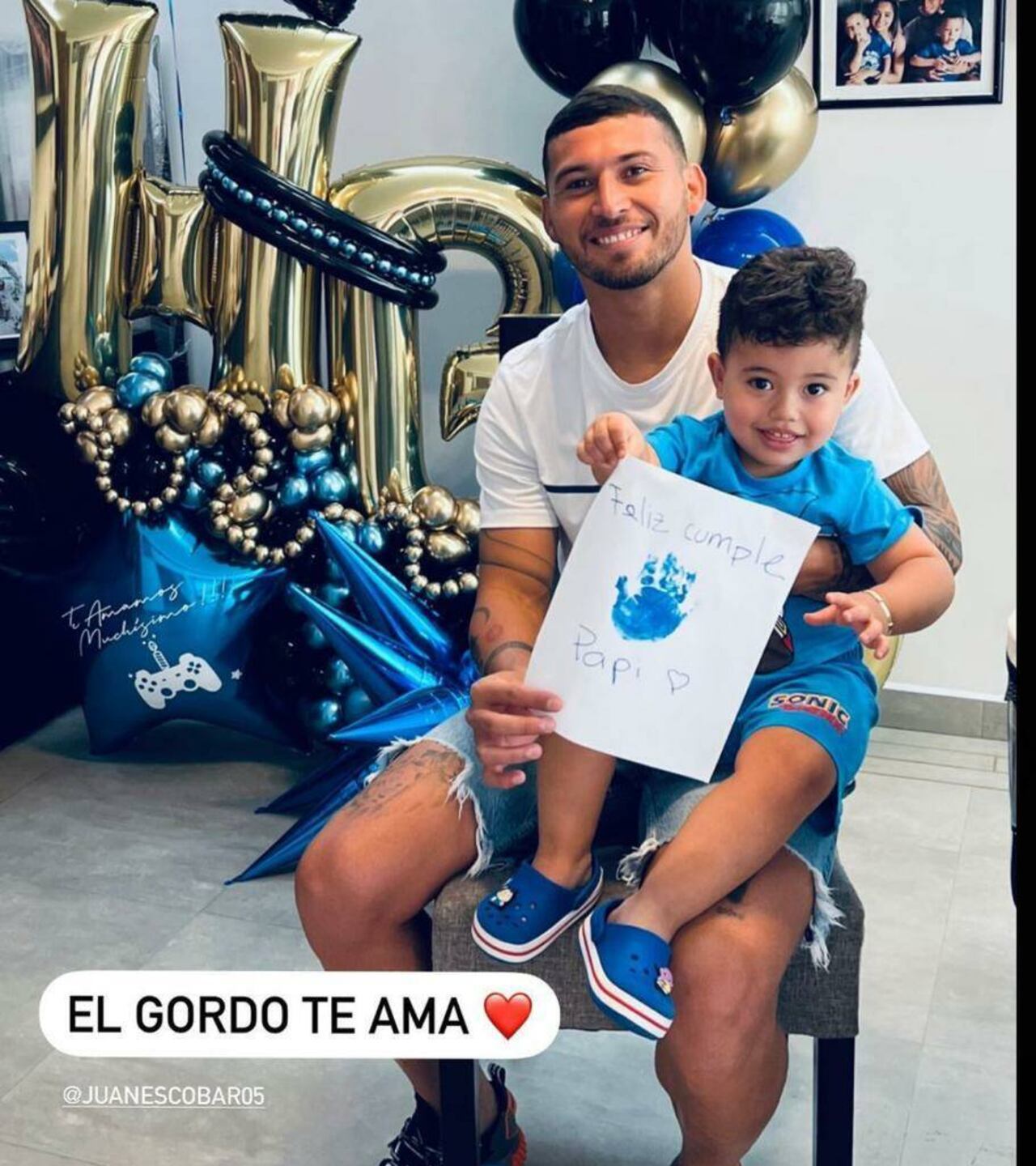 Juan Escobar con su hijo, quien le regaló un dibujito de su manito.