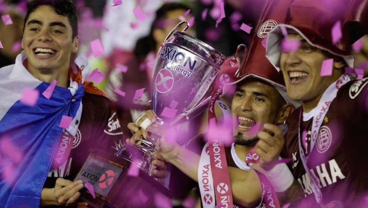 Ayala sostiene la Copa junto con Almirón y Gómez. Fueron artífices.