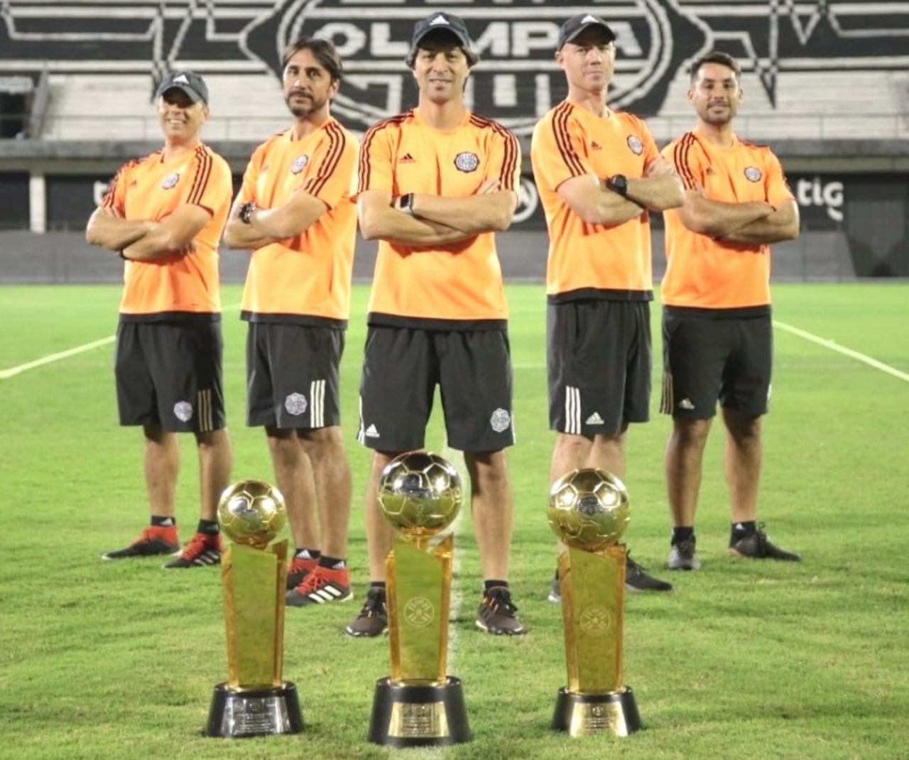 El cuerpo técnico tricampeón, posando con las Copas nacionales.