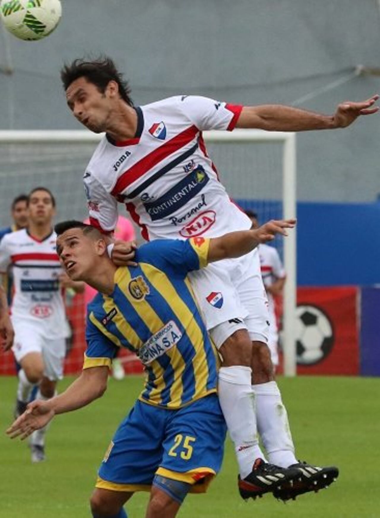 David Mendoza salta para despejar la pelota ante la presencia de Marcelo Escurra.